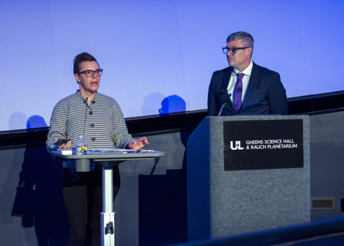 Two people speak at a podium