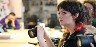 Student holds a Canon camera.