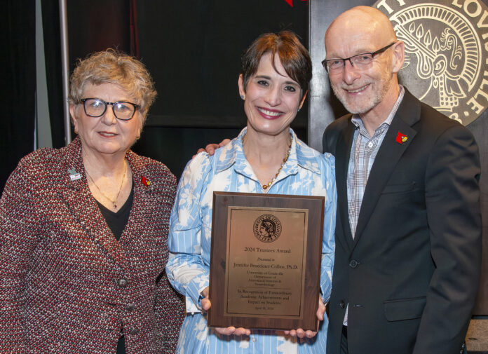 Professor Jennifer Brueckner-Collins, center, is the recipient of the 2024 University of Louisville Trustees Award. Pictured with her are Uofl President Kim Schatzel (left) and Provost Gerry Bradley (right).