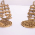 The original metal medallion worn by UofL's president in commencement ceremonies (left) and the lighter 3D printed replic (right). UofL photo by Ashly Cecil.