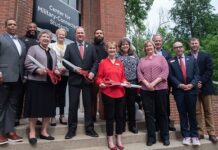A group of UofL leaders, faculty and staff take part in a ribbon cutting ceremony.