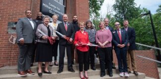 A group of UofL leaders, faculty and staff take part in a ribbon cutting ceremony.