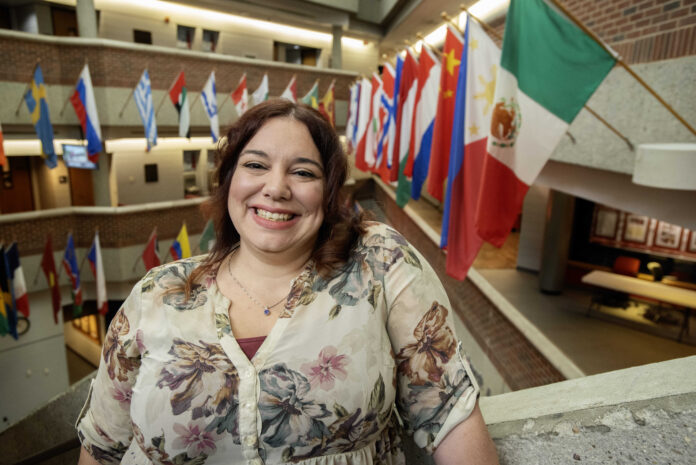 Tiffany Martin smiles beside flags of the world