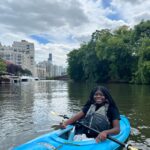 A girl in a kayak on the Chicago River with the Chicago skyline in the background