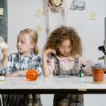 Two children exploring science at a table.