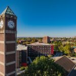 High angle shot of the Student Activities Center clock tower with downtown Louisville in the distance