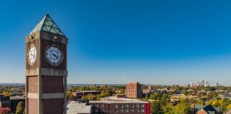 High angle shot of the Student Activities Center clock tower with downtown Louisville in the distance