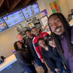Ethan McNary at a Taco Bell restaurant with team members