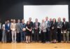Group of people holding glass awards on stage
