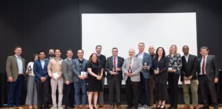 Group of people holding glass awards on stage