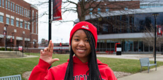 Girl in red sweatshirt holding up the 'L' sign