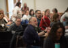 Individuals sitting at a conference.