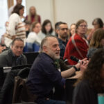Individuals sitting at a conference.