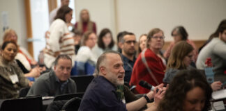 Individuals sitting at a conference.