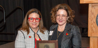 Jasmine Farrier, right, accepts the 2025 UofL Trustees Award from Interim University Provost Katie Cardarelli.