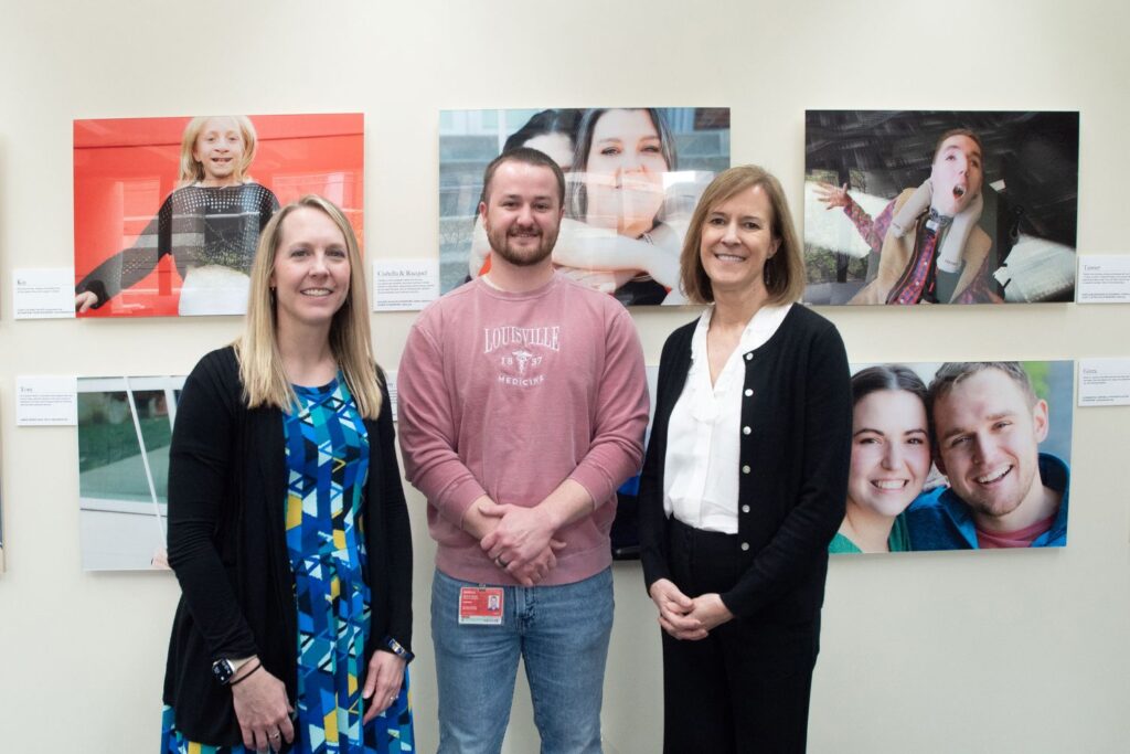 Sarah Korte, Sean Woods and Corrie Harris in front of the Positive Exposure exhibit.