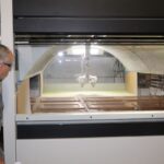 Man watching cabinet doors in sprayer