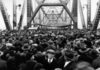 A crowd of people walking over a bridge