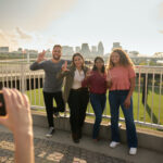 Students throwing up their L's for a group photo opportunity at the Big Four Bridge at Waterfront Park in downtown Louisville.