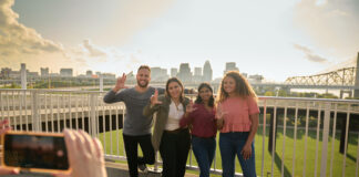 Students throwing up their L's for a group photo opportunity at the Big Four Bridge at Waterfront Park in downtown Louisville.