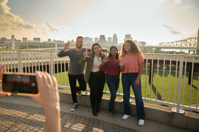Here_and_Beyond_Campaign Students throwing up their L's for a group photo opportunity at the Big Four Bridge at Waterfront Park in downtown Louisville.
