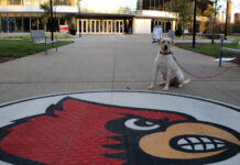 Lily, the ULPD comfort dog sits next to the Cardinal outside of BAB