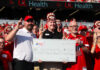 Individuals holding a large check