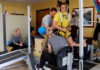 UofL researchers help paralyzed children take steps using external electrical stimulation Child on treadmill assisted by trainers