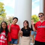UofL’s annual day of giving, Raise Some L, kicks off Oct. 21 Four students on campus with "L" signs