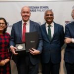 Group of four people with man holding an award.