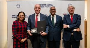 Group of four people with man holding an award.