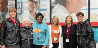 Cardinal community captures giving spirit for holidays and beyond Group of staff and students together in front of the UofL Ambulatory Care Building.