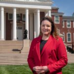 University of Louisville selects new provost Woman in red stands in front of Grawemeyer Hall.