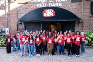 A group in front of the Red Barn raising their 'L' for UofL.