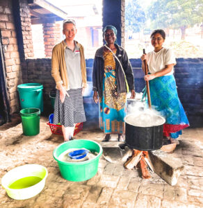 A student and professor from UofL help make porridge in Malawi.