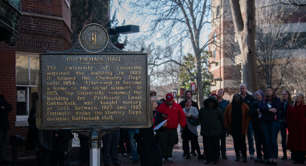 Explore UofL’s Belknap Campus through its historical markers A photo of the Gottschalk Hall historical marker with people standing around it