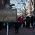 A photo of the Gottschalk Hall historical marker with people standing around it
