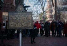 A photo of the Gottschalk Hall historical marker with people standing around it