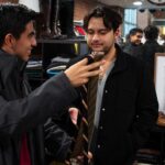 Two men look at tie choices.