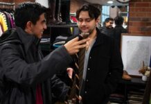 Two men look at tie choices.