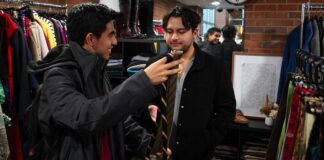 Two men look at tie choices.