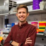 Man standing in a lab with arms crossed