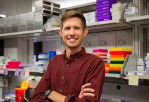 Man standing in a lab with arms crossed