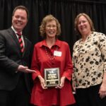 Woman holding a plaque award.