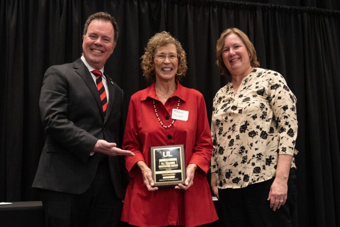 Woman holding a plaque award.