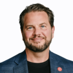 Man in jacket wearing a Pinterest logo lapel pin