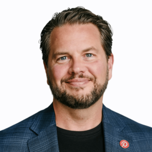 Man in jacket wearing a Pinterest logo lapel pin