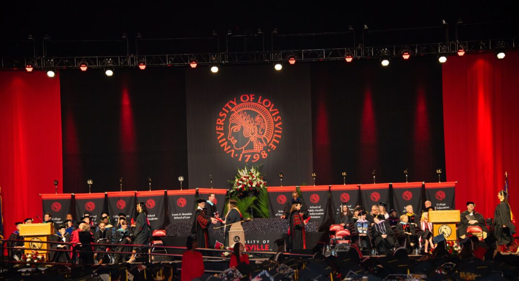 Student walks across the stage to accept a diploma
