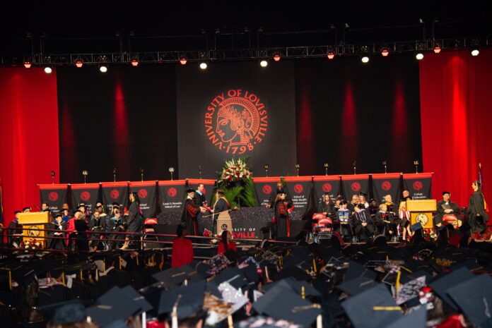 Student walks across the stage to accept a diploma