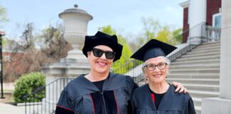 Mother and daugther, Susan and Ramie, smile in the UofL caps and gowns on campus